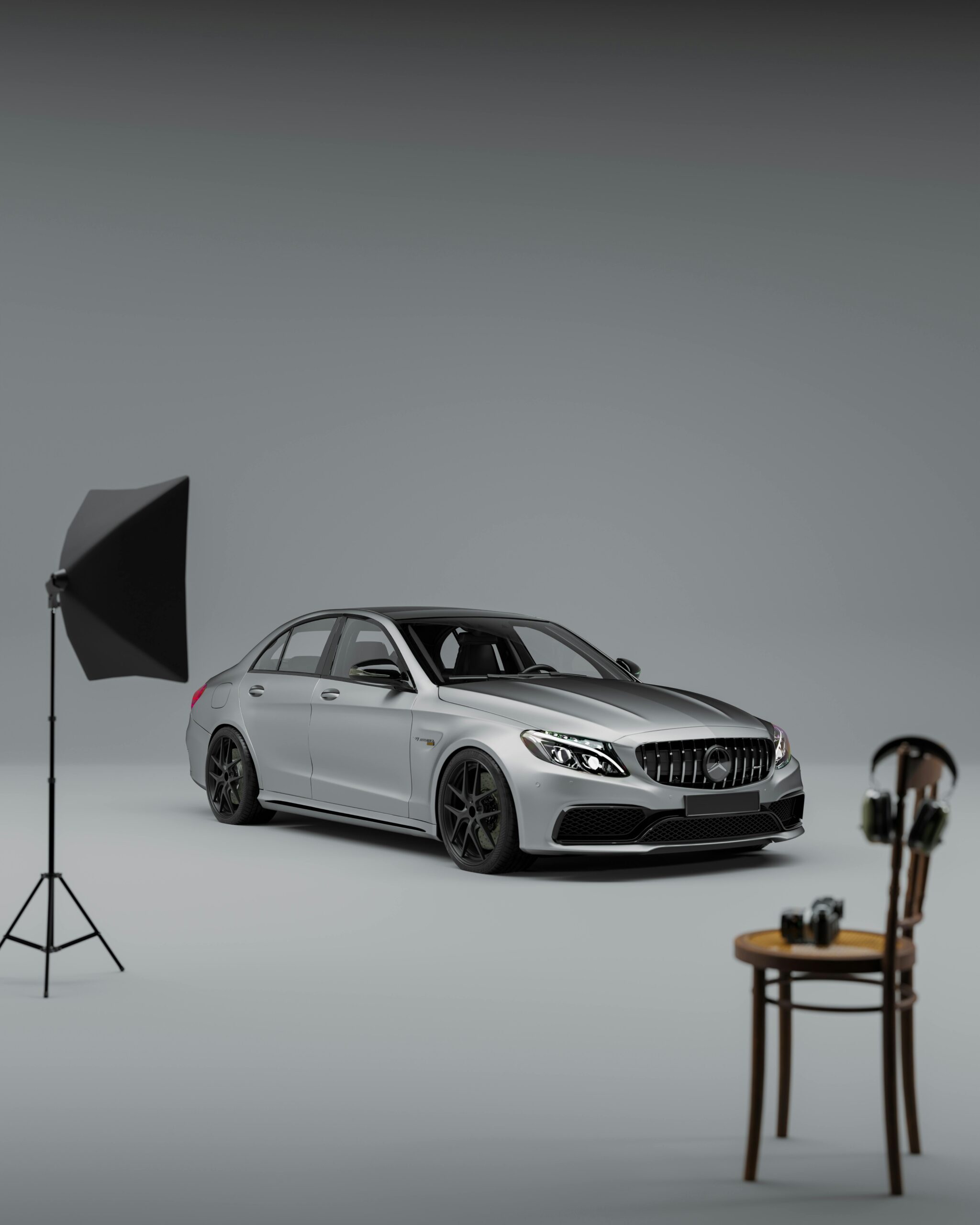 Elegant silver Mercedes car in studio with lighting setup, showcasing luxury and sophistication.